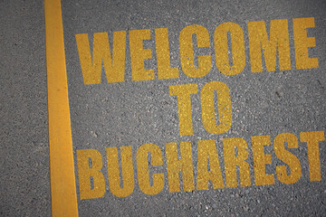 asphalt road with text welcome to Bucharest near yellow line.