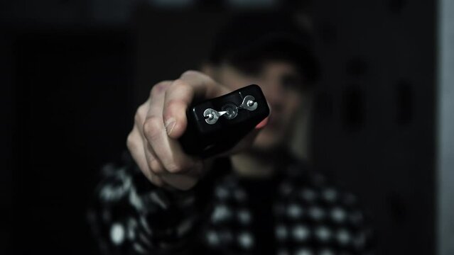 Stun gun in a man's hand, electric discharge, portable shocker, dog repeller. Slow motion camera
