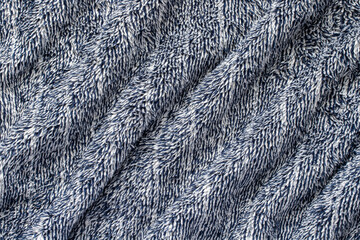 Dark blue soft fabric of cozy plush plaid. Wavy warm blanket background