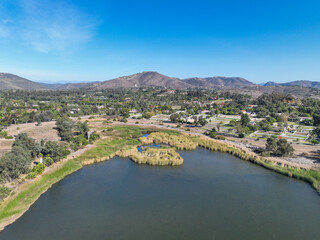 Naklejka premium Aerial view over water reservoir and a large dam that holds water. Rancho Santa Fe in San Diego, California, USA