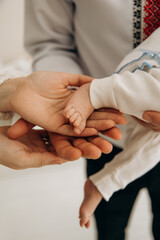 Obraz premium A close-up photo of a small child's leg in his hands. Touching the child's toes. A child's sleep
