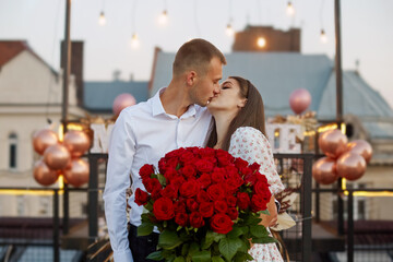 Portrait of an attractive couple holding bouquet of roses