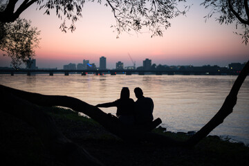 silhouette of a couple sitting on a pier in Boston 