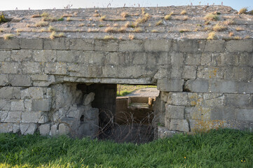 Fototapeta na wymiar Detail of German World War 2 artillery concrete bunker with barbed wire at Pointe du Hoc, Cricqueville-en-Bessin, Normandy, France