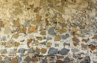 Texture of a stone wall with many big brown and grey stones armed with cement. Old castle stone wall texture background for medieval usage. Part of a stony building as a background