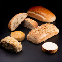 assorted cut breads on black table natural fermentation empanada and cheese cake schneke black background