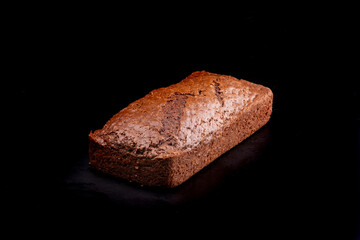 Homemade chocolate cake in the shape of a fresh loaf isolated on a black background