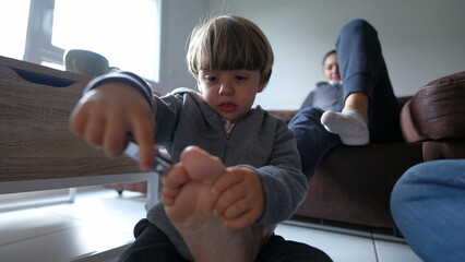 Playful Child and Mother's Pedicure Time at Home, little boy attempts to trim reluctant parent,...