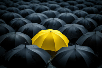 A yellow umbrella among a crowd of black umbrellas - Concept of success, of being special as a leader, with its own identity, having a difference, new ideas and special skills among the others