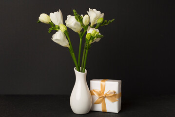 Nice bouquet of white freesia flowers in vase on table