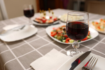 Festively laid table with glasses of red wine.