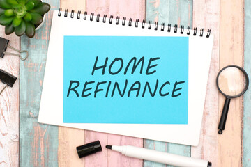 text HOME REFINANCE on blue paper composition with stationery on color background. top view