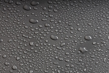 water droplets on a gray surface, a lot of drops randomly arranged on plastic