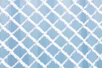 the fence is made of mesh in winter, the mesh is covered with frost and snow
