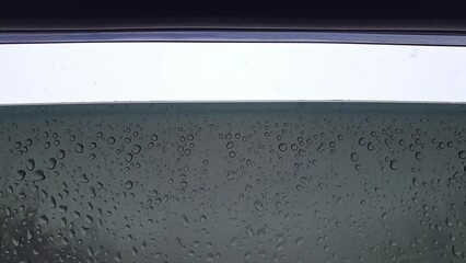 Car door window is slightly open. Large drops of melted snow on the glass. Snowflakes fall inside the cabin. Close-up. Slow motion video. - Powered by Adobe