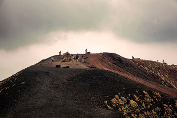 a small group of climbers travels an old crater of Etna