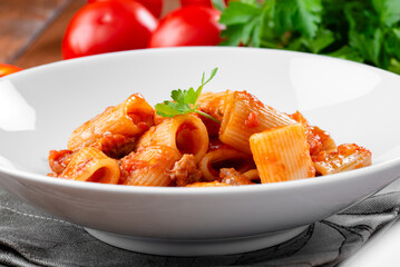 Piatto con mezzi rigatoni al sugo di salsiccia, pasta italiana, cibo europeo 