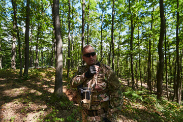 A military major employs a Motorola radio for seamless communication with his fellow soldiers during a tactical operation, showcasing professionalism and strategic coordination