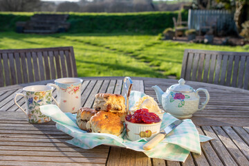 Scones with cups of tea in an English country garden. Complete with fresh Strawberry jam and...
