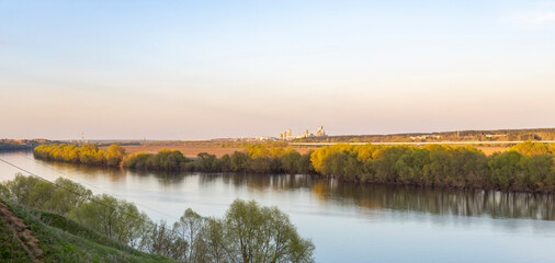 Industrial landscape near the river, large factory next to the river.Panoramic landscape of a wide river at sunset, evening