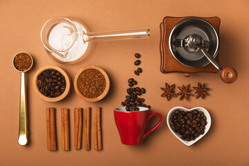 Ingredients for making coffee. Moka pot, Turkish coffee pots (cezve), coffee grinder with coffee beans, milk, sugar and spices on a brown background. Drink preparation concept. Flat Lay.Copy space.