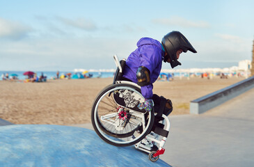 athlete man with disability in wheelchair performing tricks in skatepark on the beach