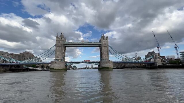 The Tower Bridge in London filmed from the River Thames with a bus crossing.