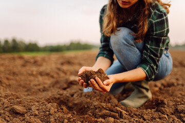 Farmer hands touching soil on the field. Expert hand of farmer checking soil health before growth a seed of vegetable or plant seedling. Concept of agriculture, business and ecology.