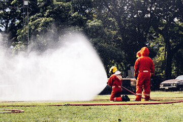 Fototapeta premium Firefighter Concept. Several firefighters go offensive for a fire attack. Fireman using water and extinguisher to fighting with fire flame.
