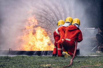 Firefighter Concept. Several firefighters go offensive for a fire attack. Fireman using water and...