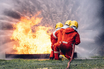 Firefighter Concept. Several firefighters go offensive for a fire attack. Fireman using water and...