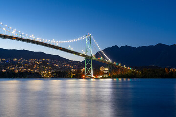 A long exposure photo during blue hour of Lions Gate Bridge in Vancouver, British Columbia with...