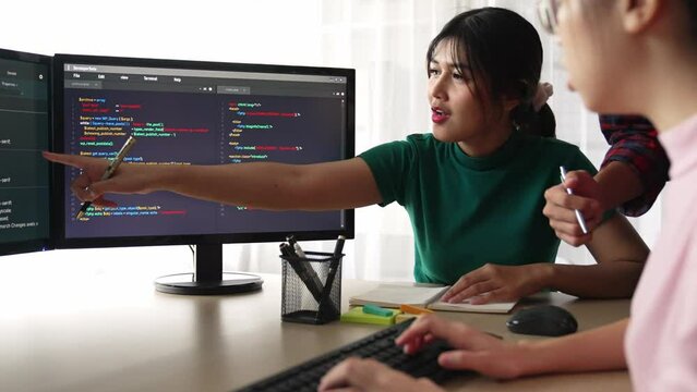 Slow motion back end software developer engineer for computer programming working together on debugging writing computing code, solving complex algorithms display on monitor in office. Burgeoning