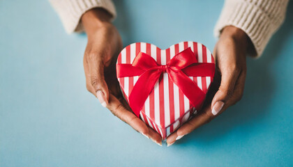 female hands cradle a heart-shaped gift, embodying love and celebration for occasions like Valentine's Day, birthdays, and Mother's Day