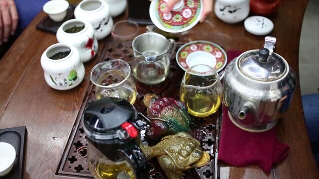 Female hands pour water into teapot during tea ceremony