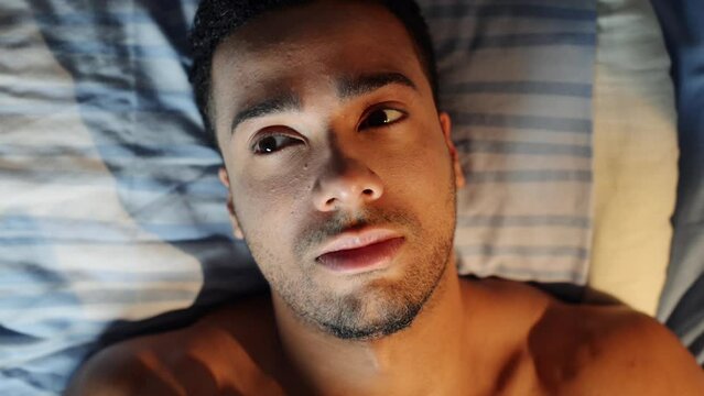 Man, fatigue and insomnia or sleepless in bed, mental health and depression or awake at night. Male person, stress and worry for mistake and fail at home, tired and exhausted in dark or anxious