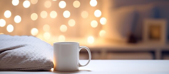 Bedside table with white mug against the bed at night time.