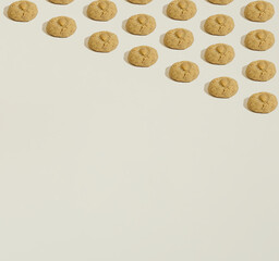 A pattern made of almond cookies geometrically laid out on a dark beige background. Copy space. Sweets minimal concept.