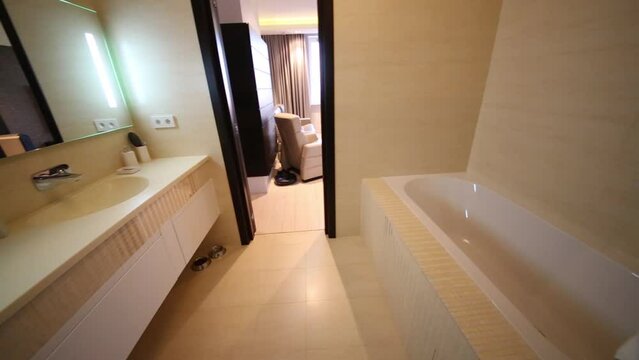 Bathroom with bathtub, the living room is seen through the open door