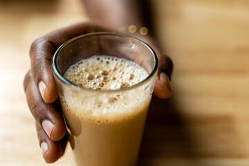 A Hand Cradling a Glass of Tea