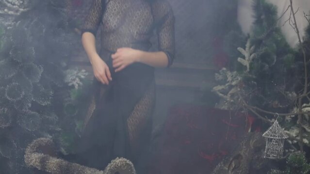 Woman in transparent dress without bra sitting in small decorated sled
