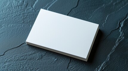 Blank sheet, business card on a dark background. View from above.