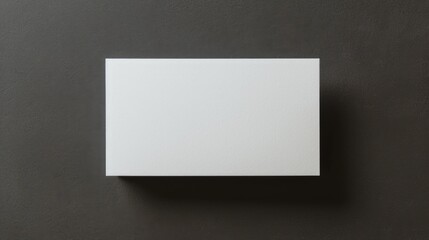 Blank sheet, business card on a dark background. View from above.