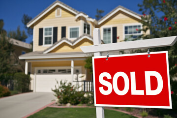 Red sold sign in front of a house, real estate market, home ownership