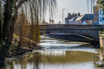 Fototapeta na wymiar A view towards the Church Street bridge over the River Welland in the centre of Spalding, Lincolnshire on a bright sunny day
