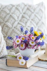 Beautiful spring or summer floral composition with daisy camomile flowers in a white cup for countryside table decor. Greeting card for Women's or Mother's Day, 8th of March. Wooden background