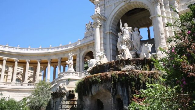 Water flows down the fountain with the statues in the Longchamp Palace