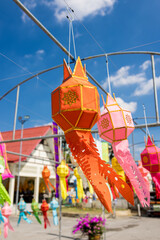 A group of vibrant lanterns suspended from a tall pole at Wat Chiang Man, creating a colorful and...