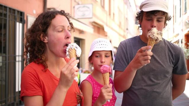 Mother with two children eating ice cream on the walk