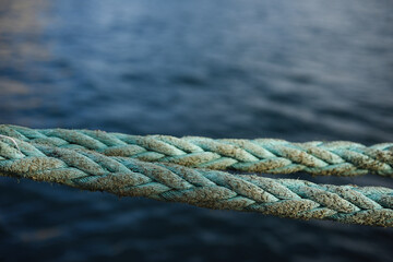 Detail of worn rope on dock with sea in background